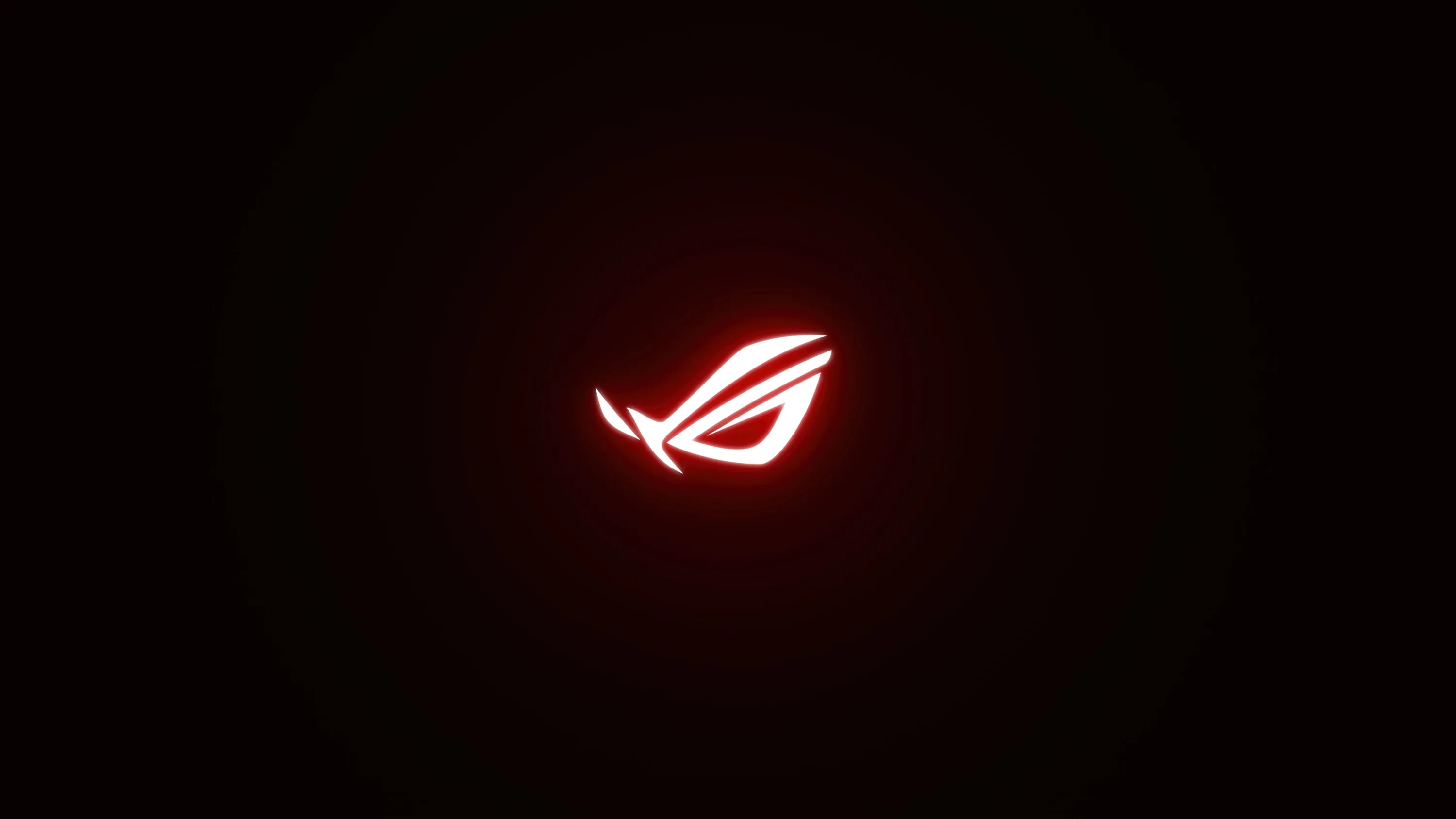 The ROG eye burns red at the middle of an otherwise empty black field, its glow bleeding out in a soft circular halo.
