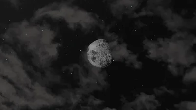 A half-lit moon tilts among ragged grey clouds and faint stars, the left half of the frame staying darker where desktop icons can sit.