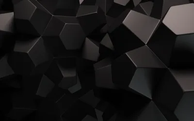 Chunky matte black hexagons and cubes press together across the frame, each edge catching just enough grey light to separate one block from the next.