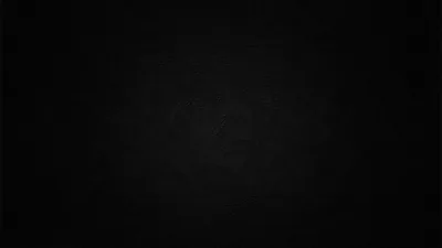 Almost the whole frame sits at true black, a faint circular grain surfacing near the middle before the corners fade out completely.