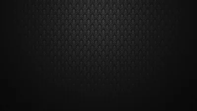 A repeating fleur motif covers a wall-like surface, lit from above so only the top third shows the pattern and the rest sinks to black.