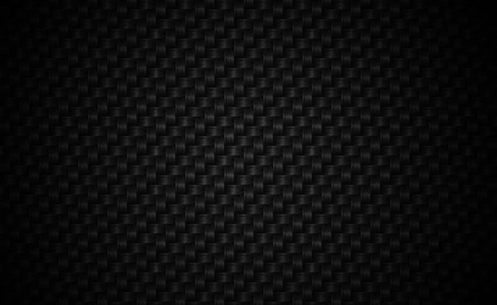 A tight carbon weave runs across the whole frame, the pattern only readable where light grazes the middle.