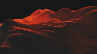 Folds of red satin roll like dunes across the lower half, the upper half held in complete black for a clean desktop workspace.