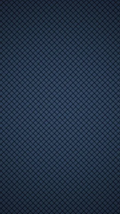 A tight quilted grid of diamonds in slate navy fills the frame edge to edge, lit slightly brighter through the centre than at the corners.