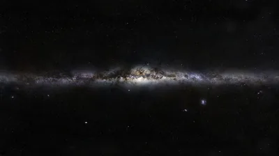 The galaxy seen flat from the side, its core swelling in the centre and the disc tapering to both edges against an almost empty sky.