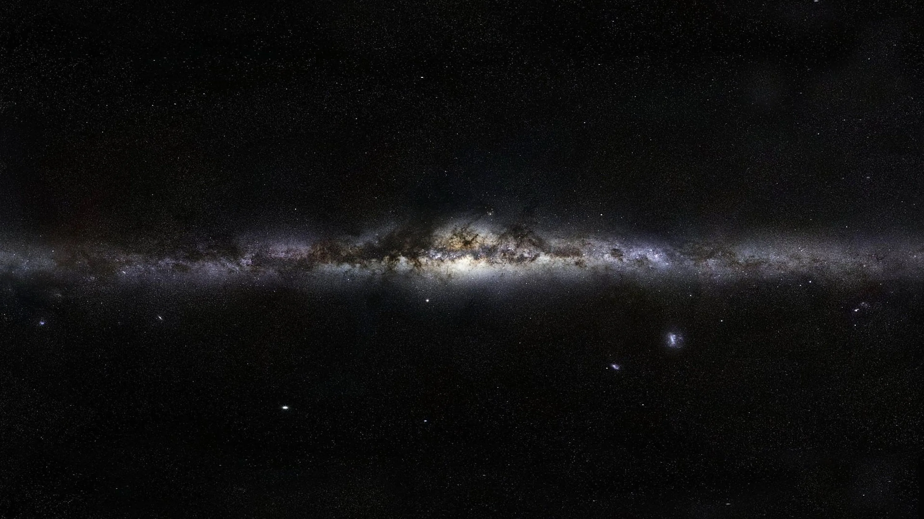 The galaxy seen flat from the side, its core swelling in the centre and the disc tapering to both edges against an almost empty sky.