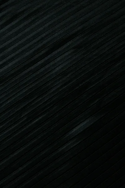 Fine brushed lines sweep corner to corner across a portrait frame, one pale scratch breaking the pattern low on the right.
