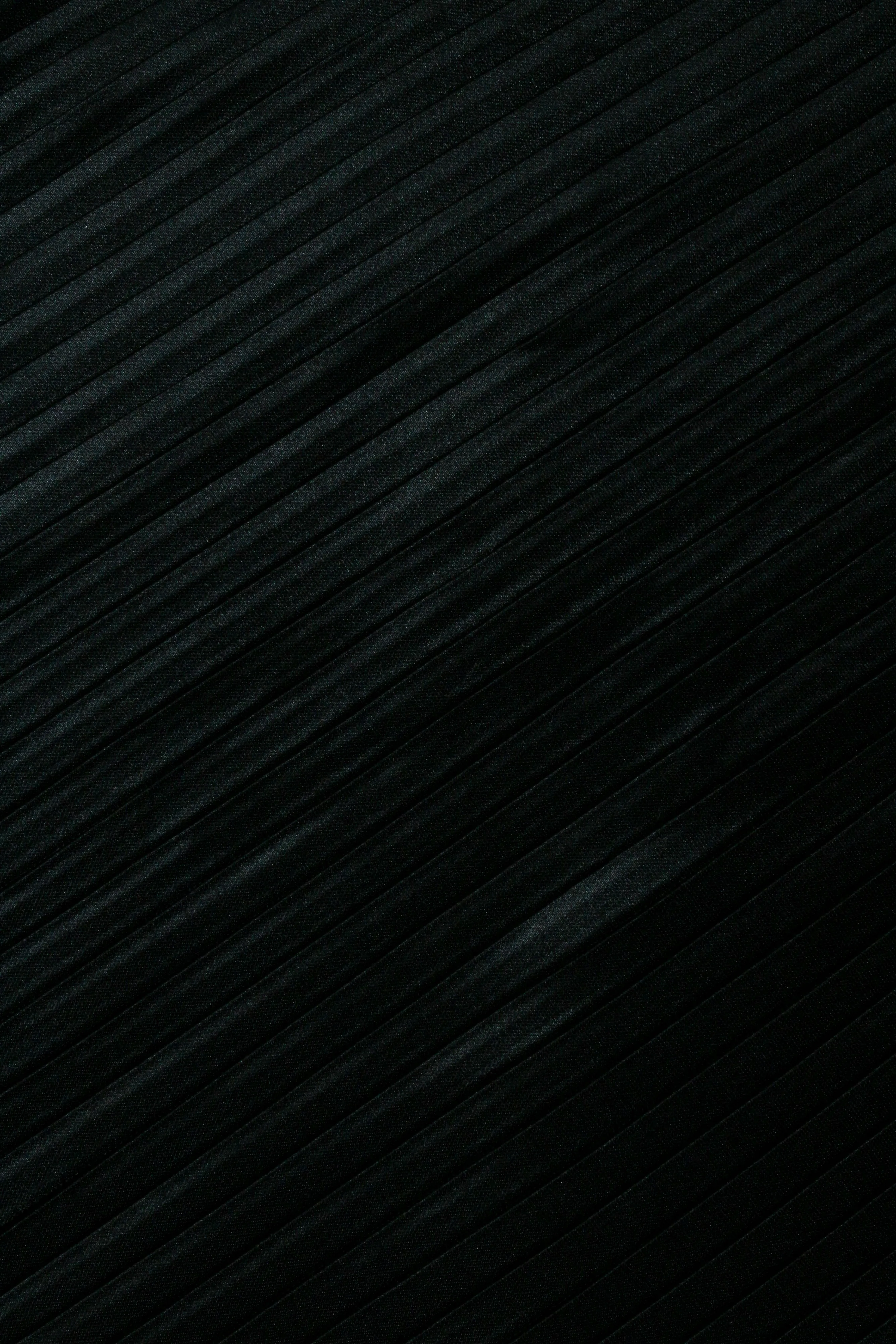 Fine brushed lines sweep corner to corner across a portrait frame, one pale scratch breaking the pattern low on the right.