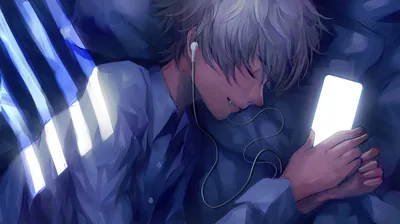 A silver-haired boy sleeps against blue bedding with earbuds in, his phone screen glowing white in both hands, striped window light falling on the wall at the left.