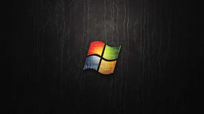 The four-colour flag sits small at the centre of a dark grained wood panel with vertical scratches.