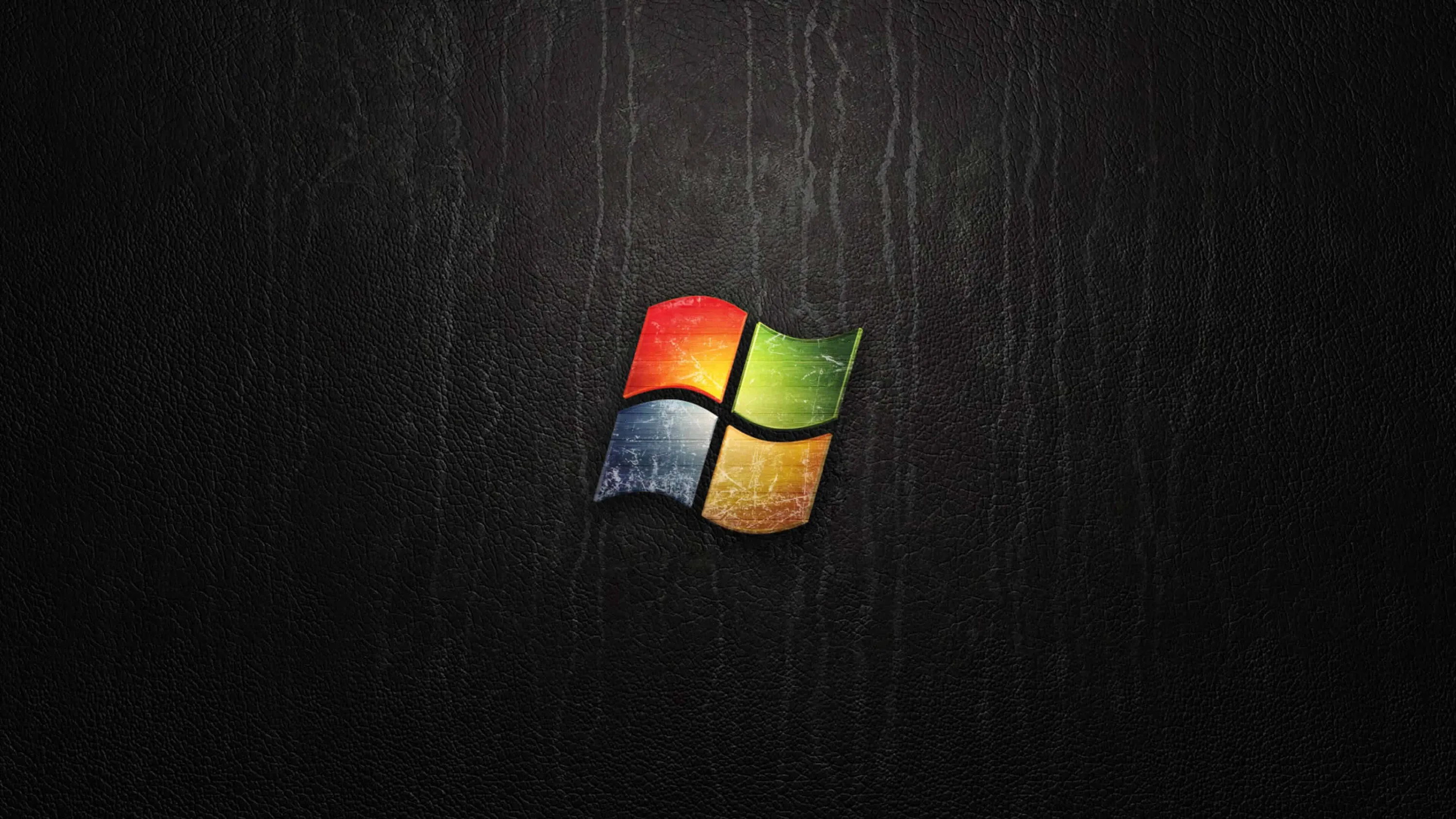 The four-colour flag sits small at the centre of a dark grained wood panel with vertical scratches.