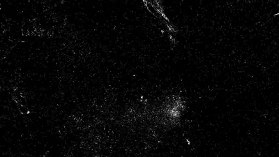 A bright knot of stars sits low and right of centre, dust and faint streaks spreading across the rest of the black field.