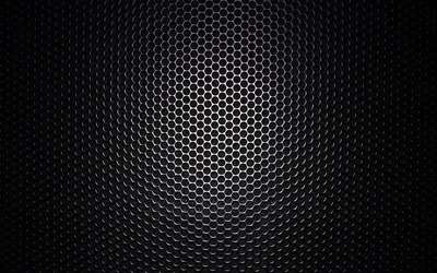 A honeycomb metal grille curves away from the viewer, the mesh catching light along the top and dissolving into black at the sides.