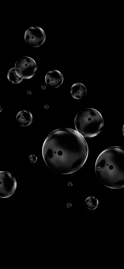 Glass spheres drift across a black field at different sizes, each one carrying a small paired highlight from a light somewhere above.