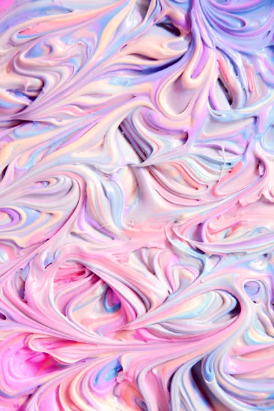 Whipped swirls of pink, lilac and pale blue frosting fill the whole frame like buttercream, glossy ridges catching the light.
