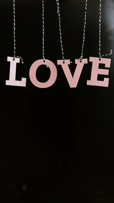 Four pale pink letters dangle from twisted cords across the upper half of a black background, leaving room below for icons.