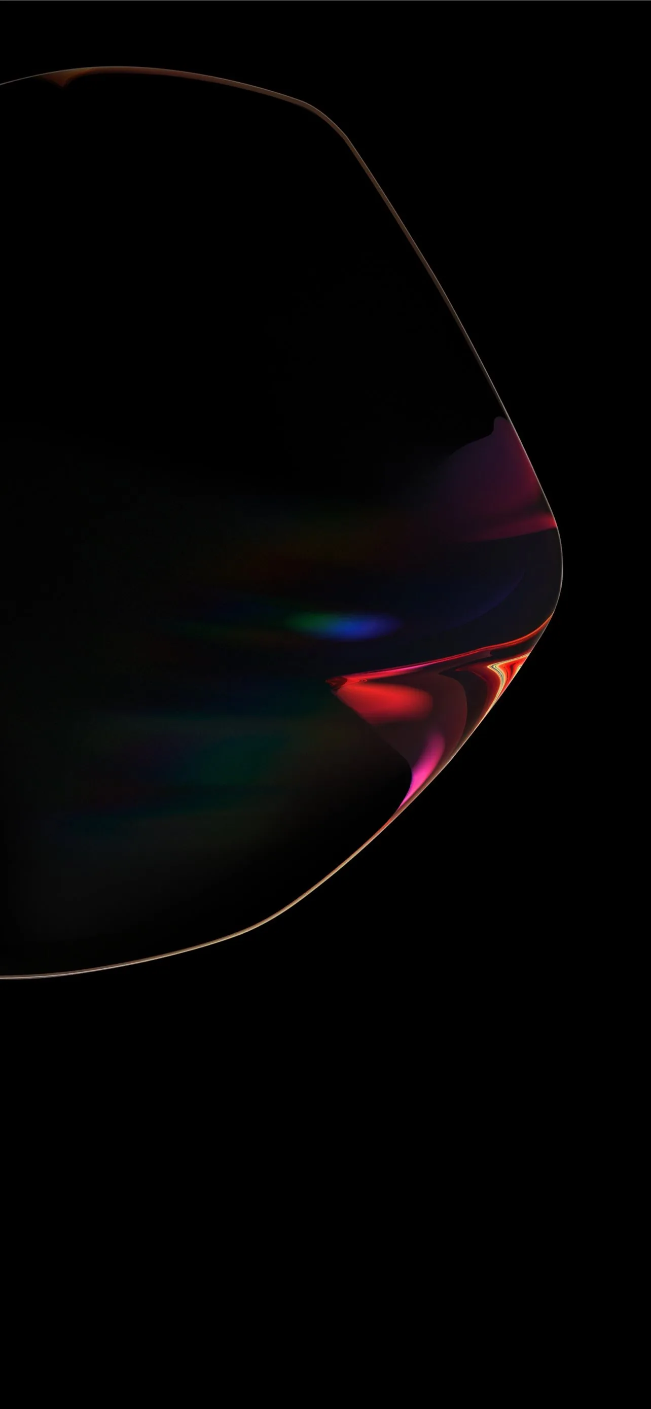 A dark rounded form fills the upper frame, its lower edge catching a smear of pink and green refraction before everything drops back to black.
