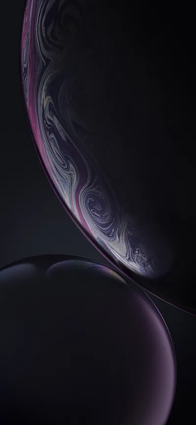 Two purple spheres overlap in low light, the larger one marbled with swirling cloud bands and rimmed by a thin magenta highlight.