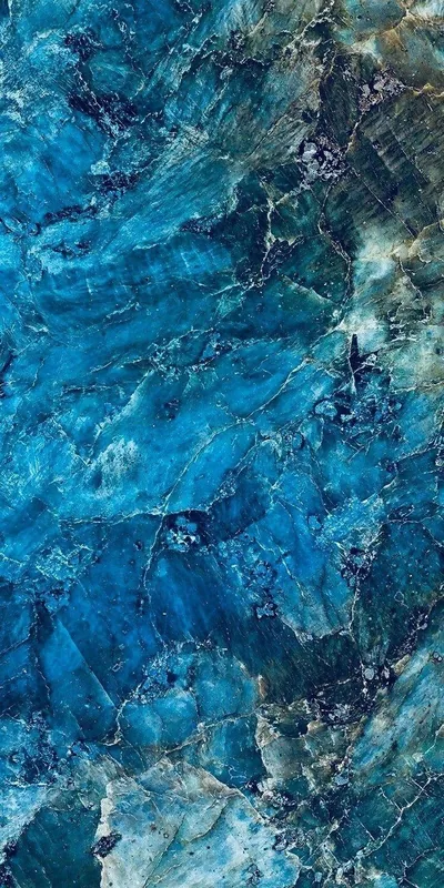 Vivid cobalt and turquoise crystal faces webbed with fine white fractures, rusty gold mineral creeping in along the bottom edge and the upper right corner.