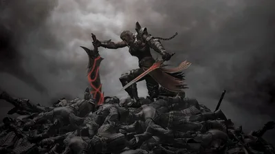 A horned warrior in a red cloak stands atop a heap of fallen armour, ash-grey clouds filling the sky behind.