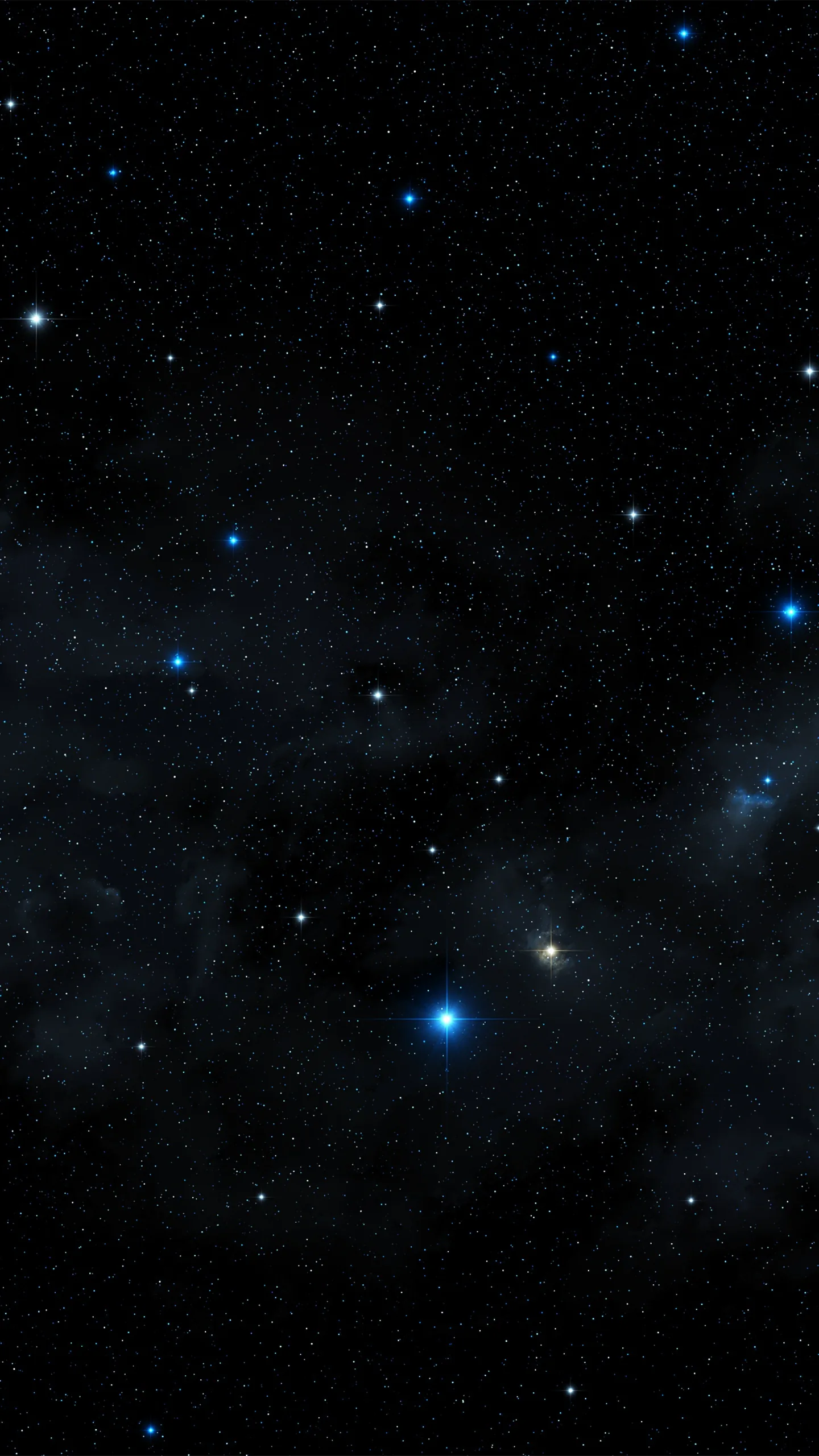 Deep blue nebula haze gathers along the bottom of this tall frame while brighter blue stars sit apart in the clear black above.