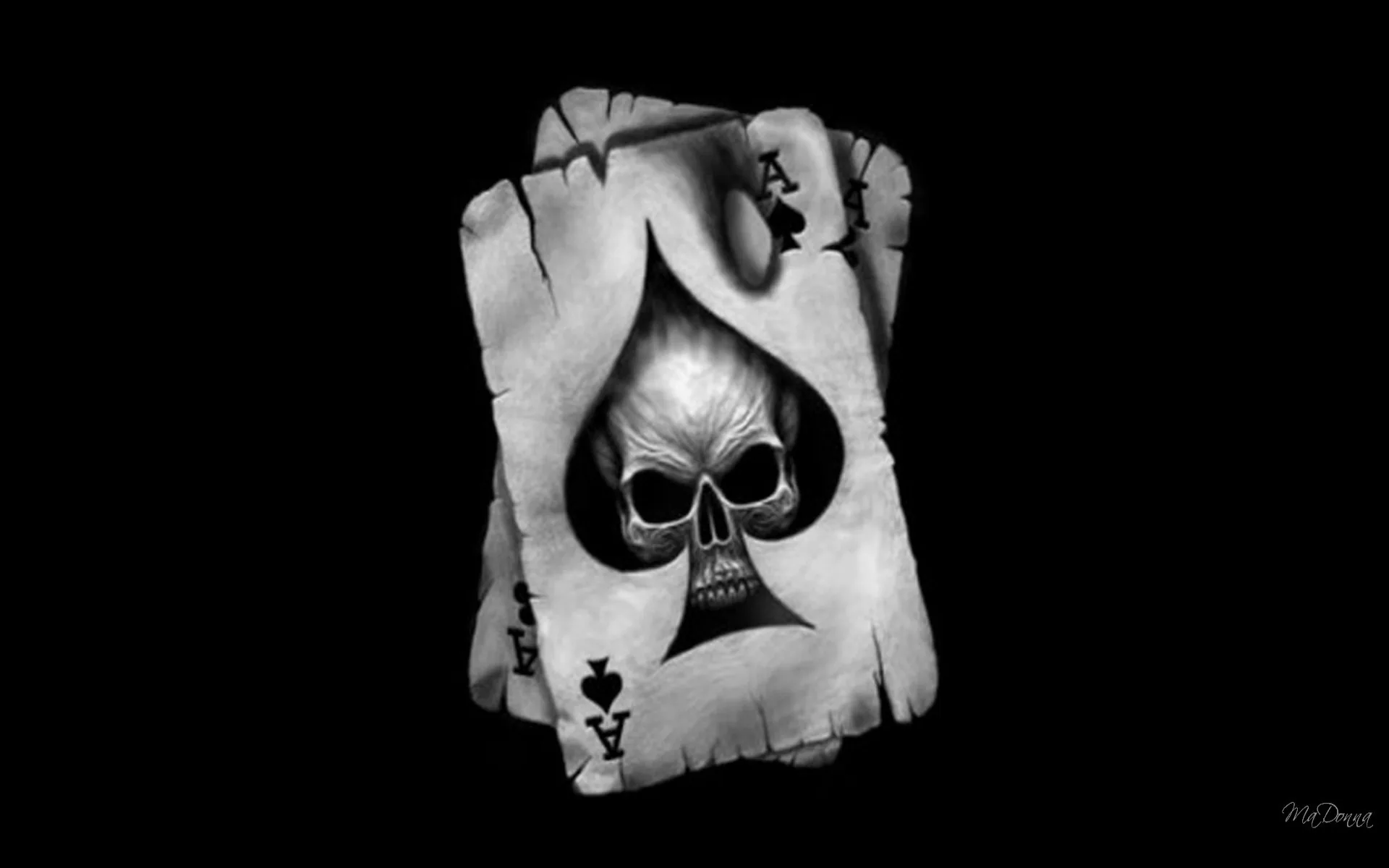 A worn playing card carries a skull inside the spade symbol, lit from above against solid black.