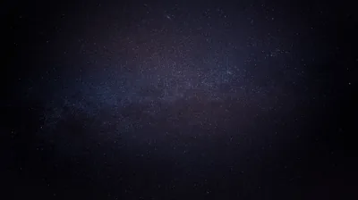 Nearly the whole frame is unbroken black, the galactic core surfacing only as a dim blue-grey blur near the centre.