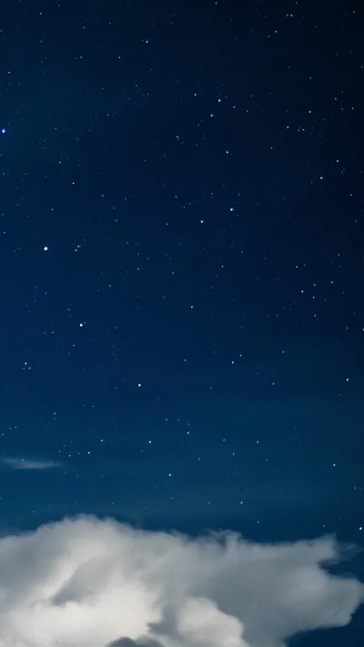 Scattered stars on a navy sky with a bank of white cloud rising from the bottom edge — the upper two thirds stay dark and uncluttered.