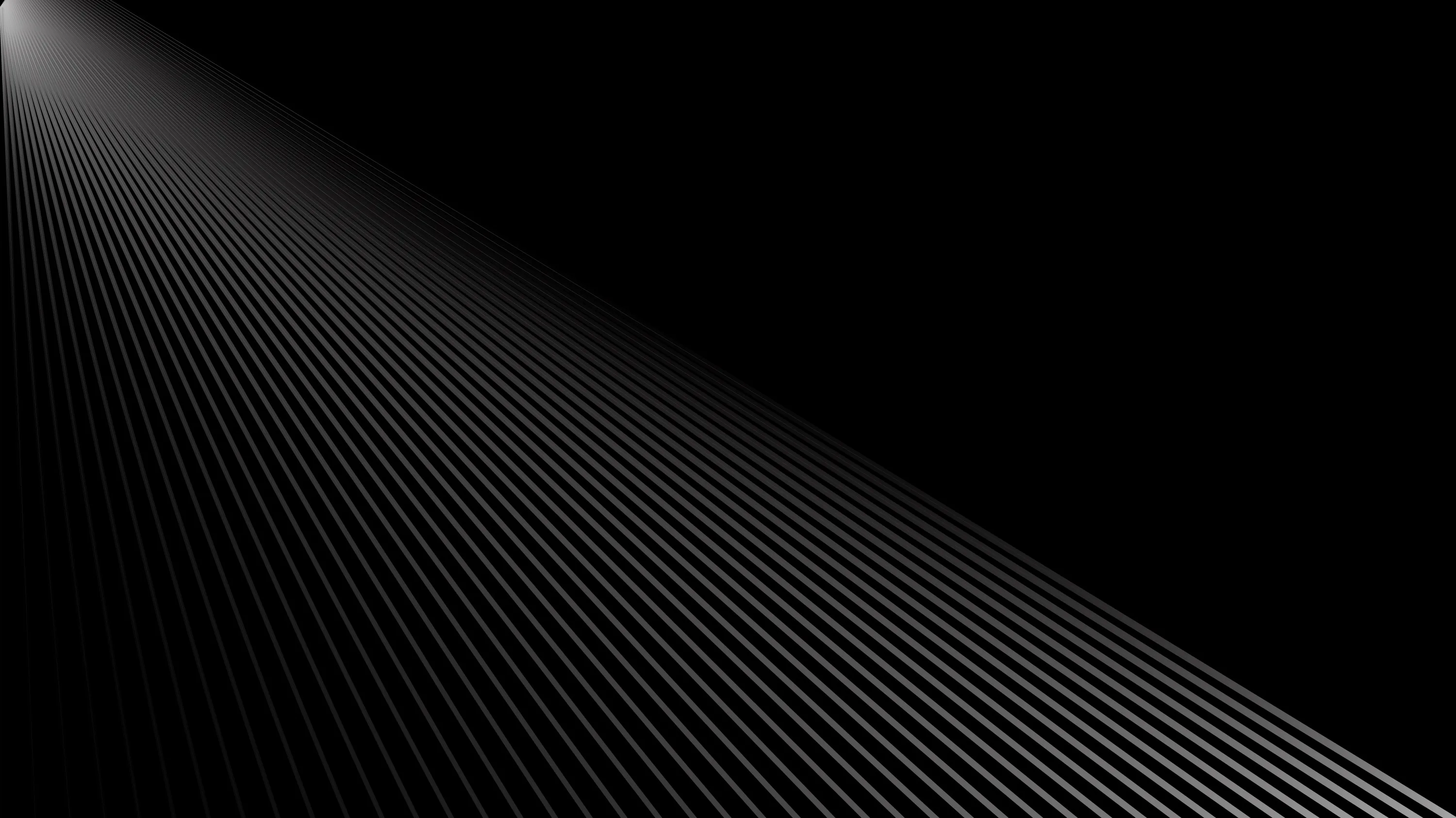 A field of thin parallel lines runs off to the upper right, catching light along one edge before the pattern drops away into pure black at the corners.