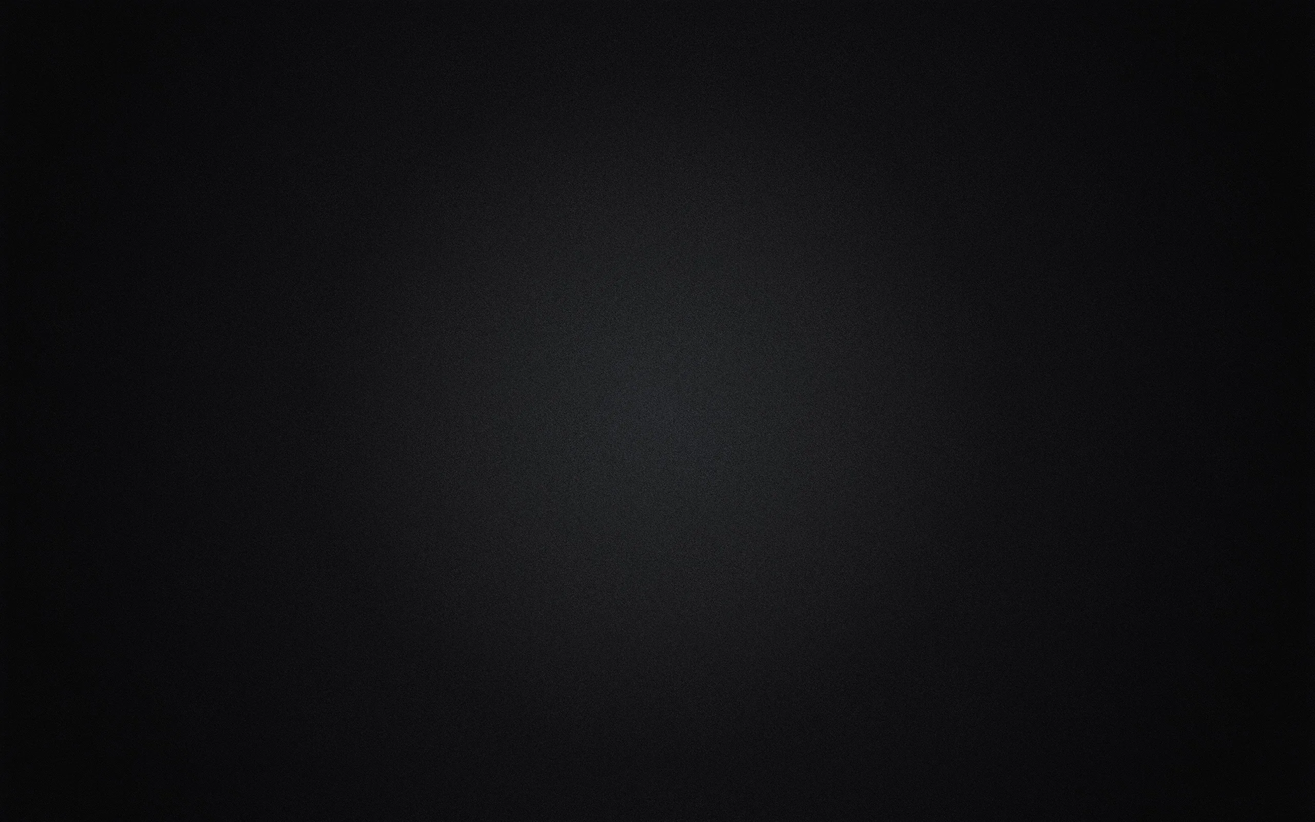 A diffuse grey glow sits slightly above centre and falls away evenly in every direction, leaving the corners in near-total black.