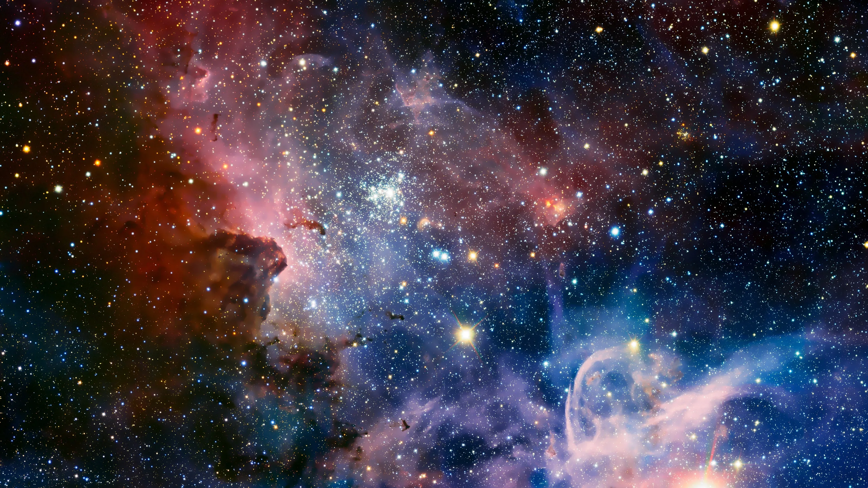 Wide view of the Carina Nebula with red dust towers on the left and a blue gas plume lower right, star-filled from corner to corner.