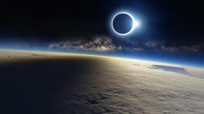 A total eclipse burns a black ring above Earth's clouded horizon, the Milky Way leaning behind it — the dark left corner keeps a clock readable.