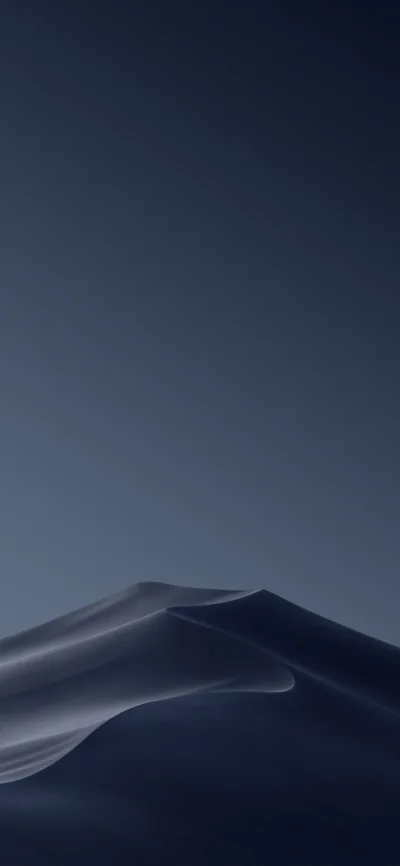 A single dune curves across the bottom third, its crest lit while the sky above stays a deep slate blue — space clear for icons.