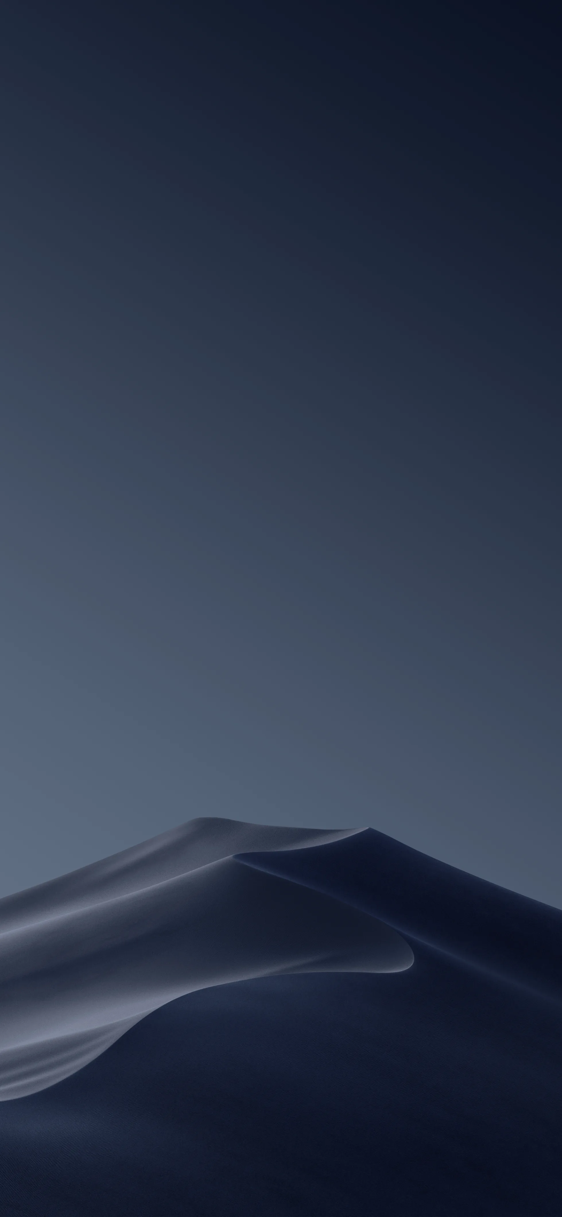 A single dune curves across the bottom third, its crest lit while the sky above stays a deep slate blue — space clear for icons.