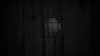 The Android robot and wordmark are pressed faintly into vertical dark wood boards, the grain running top to bottom under a heavy vignette.
