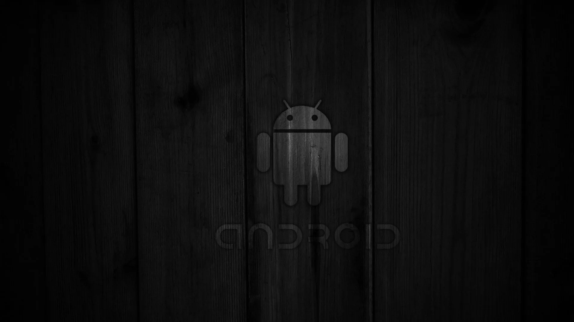 The Android robot and wordmark are pressed faintly into vertical dark wood boards, the grain running top to bottom under a heavy vignette.