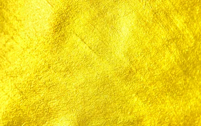 A scraped, plaster-like metallic surface in lemon gold, faint diagonal strokes and pitting spread evenly across the whole frame.