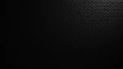 A tight carbon fibre weave fills the frame, the pattern picked up by faint light from the left while the right side drops into flat black.