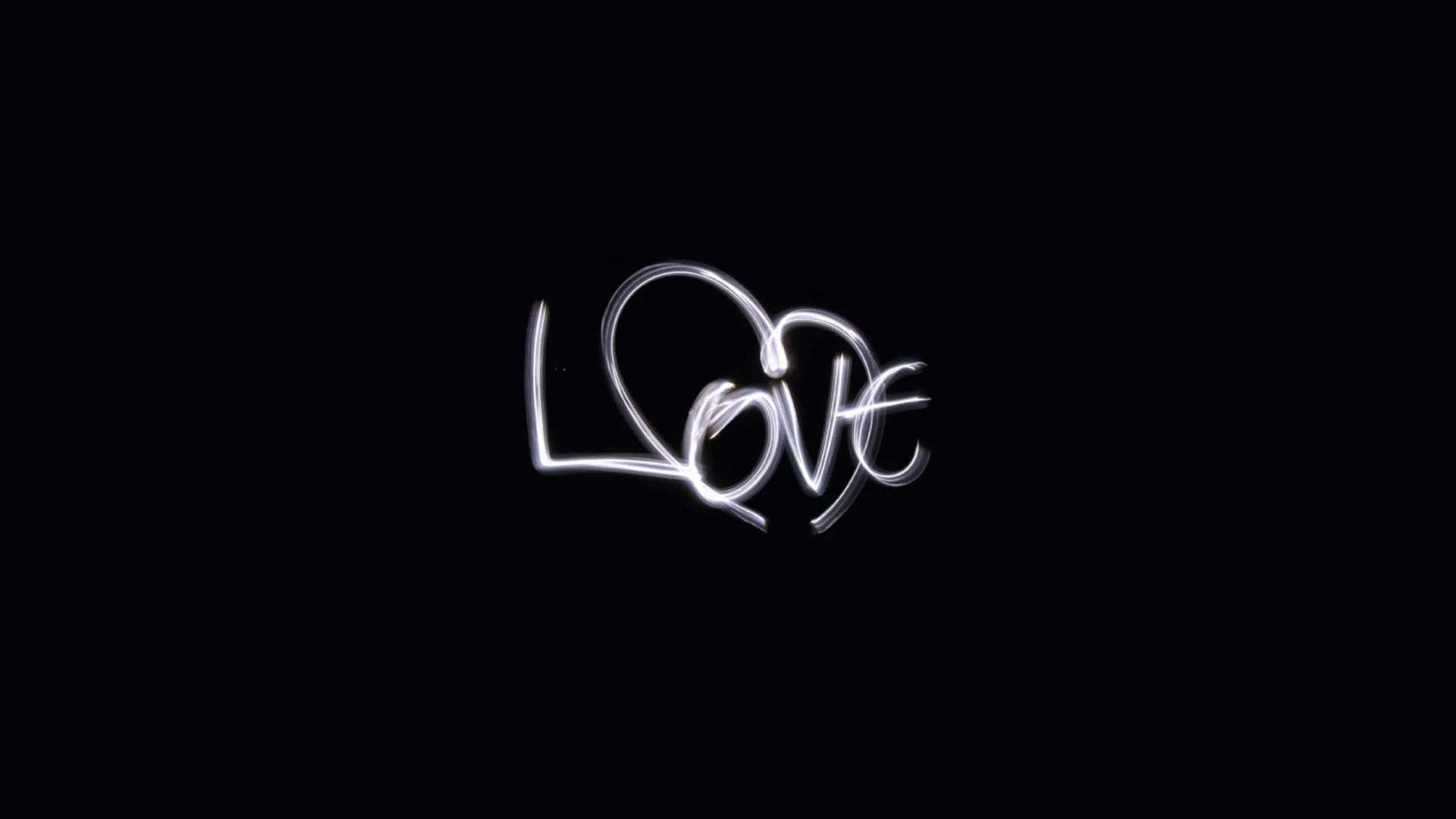 The word love drawn in one continuous white stroke, the L looping into a heart, centred on a black field with wide empty space around it.