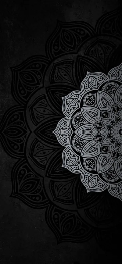 A layered mandala drawn in pale grey petals sits centre-right on a rough black wall, the pattern fading out toward the darker edges.