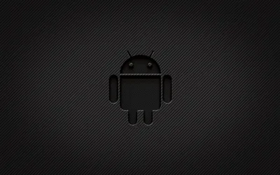 The Android robot in glossy black sits on a woven carbon fibre weave, its shape readable only from the stitched highlight along each edge.