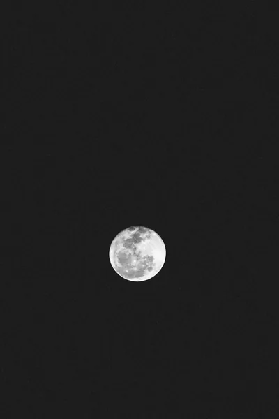 One small cratered moon floats just below centre on a charcoal-black field, leaving the whole top half empty for a clock and status bar.