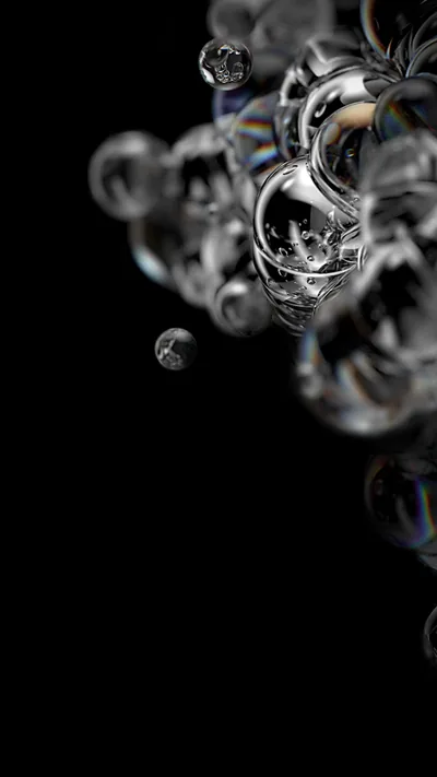 A cluster of glass-like bubbles gathers in the upper half of a vertical black frame, each one catching a thin rainbow along its rim.