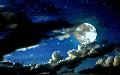 A bright full moon hangs in a deep blue star field, dark cloud banks crossing the lower half and keeping the corners near black.