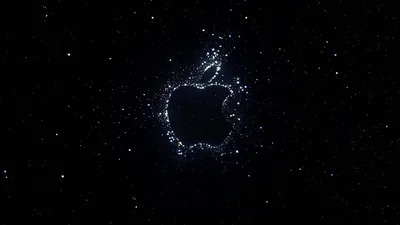 The Apple mark drawn out of scattered white specks against a deep black sky, the surrounding dots thinning into empty space.