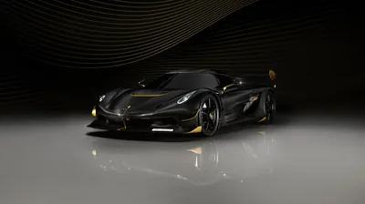 Gold winglets and wheel accents trace a black Jesko standing on a reflective studio floor, a rippled dark backdrop curving behind.