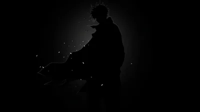 Almost the entire frame is black; a crouched figure and a scatter of small white embers are the only things the eye can find.