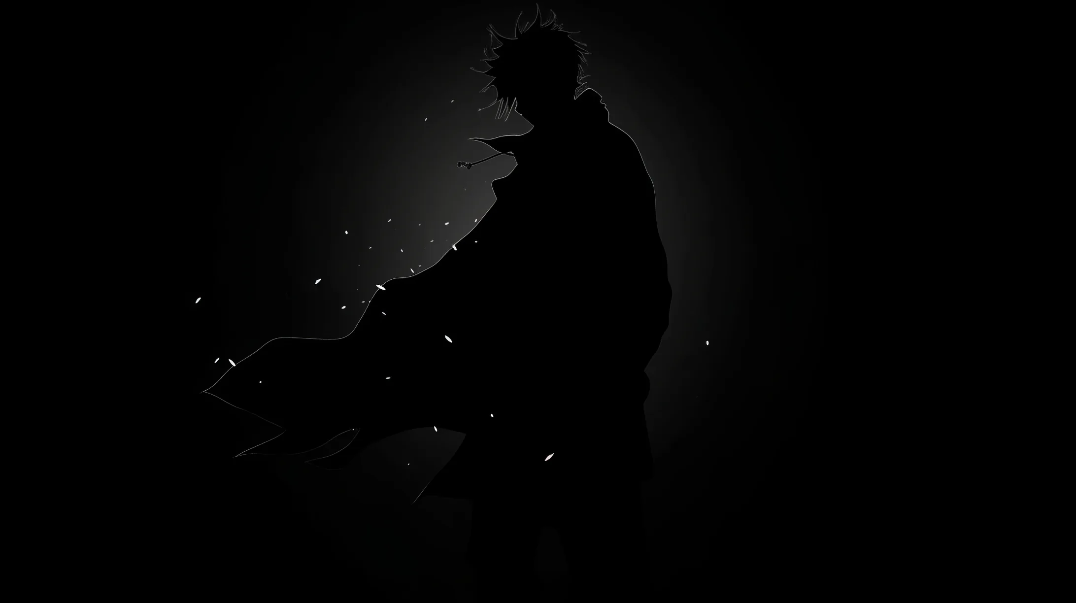 Almost the entire frame is black; a crouched figure and a scatter of small white embers are the only things the eye can find.