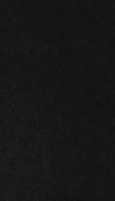 A flat black cloth fills the whole frame, its weave only visible where the light grazes it, with no pattern or highlight anywhere.