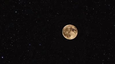 A small golden moon sits alone in a wide field of stars, with so much dark sky around it that icons fit almost anywhere.
